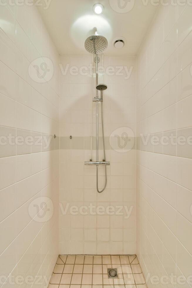 A shower with a shower head and a tiled floor photo