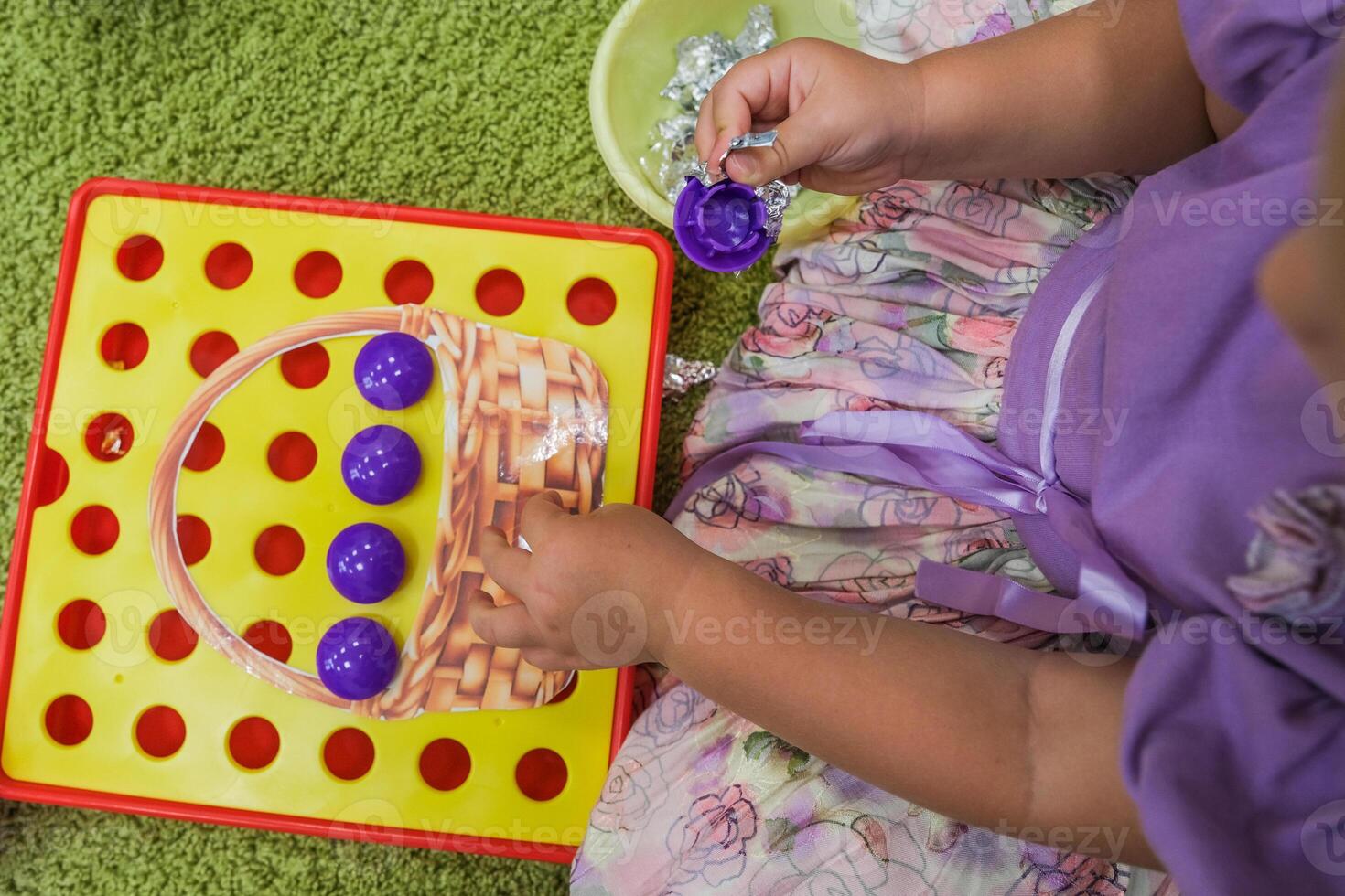 A child collects a puzzle for the development of fine motor skills photo