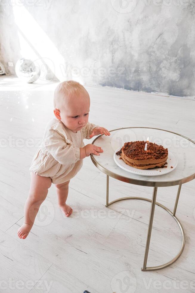 Baby girl celebrating her birthday with birthday cake photo