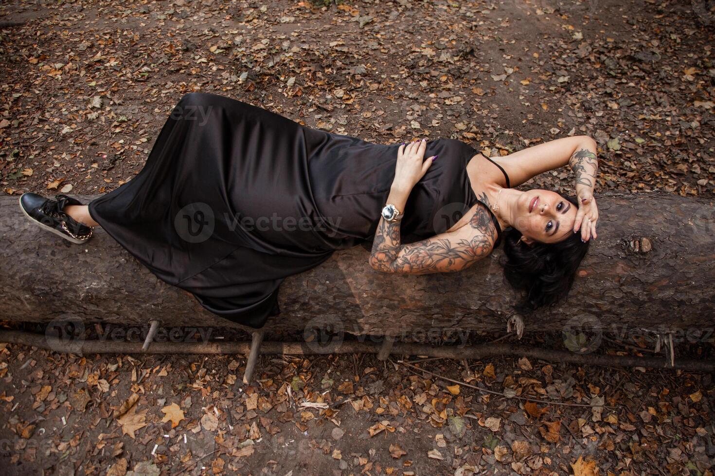 Portrait of chic dark-haired tattooed young woman photo
