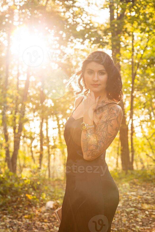 Portrait of chic dark-haired tattooed young woman photo