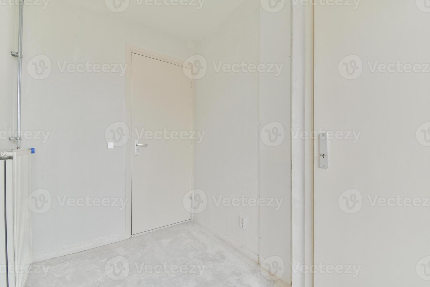An empty room with white walls and a door photo