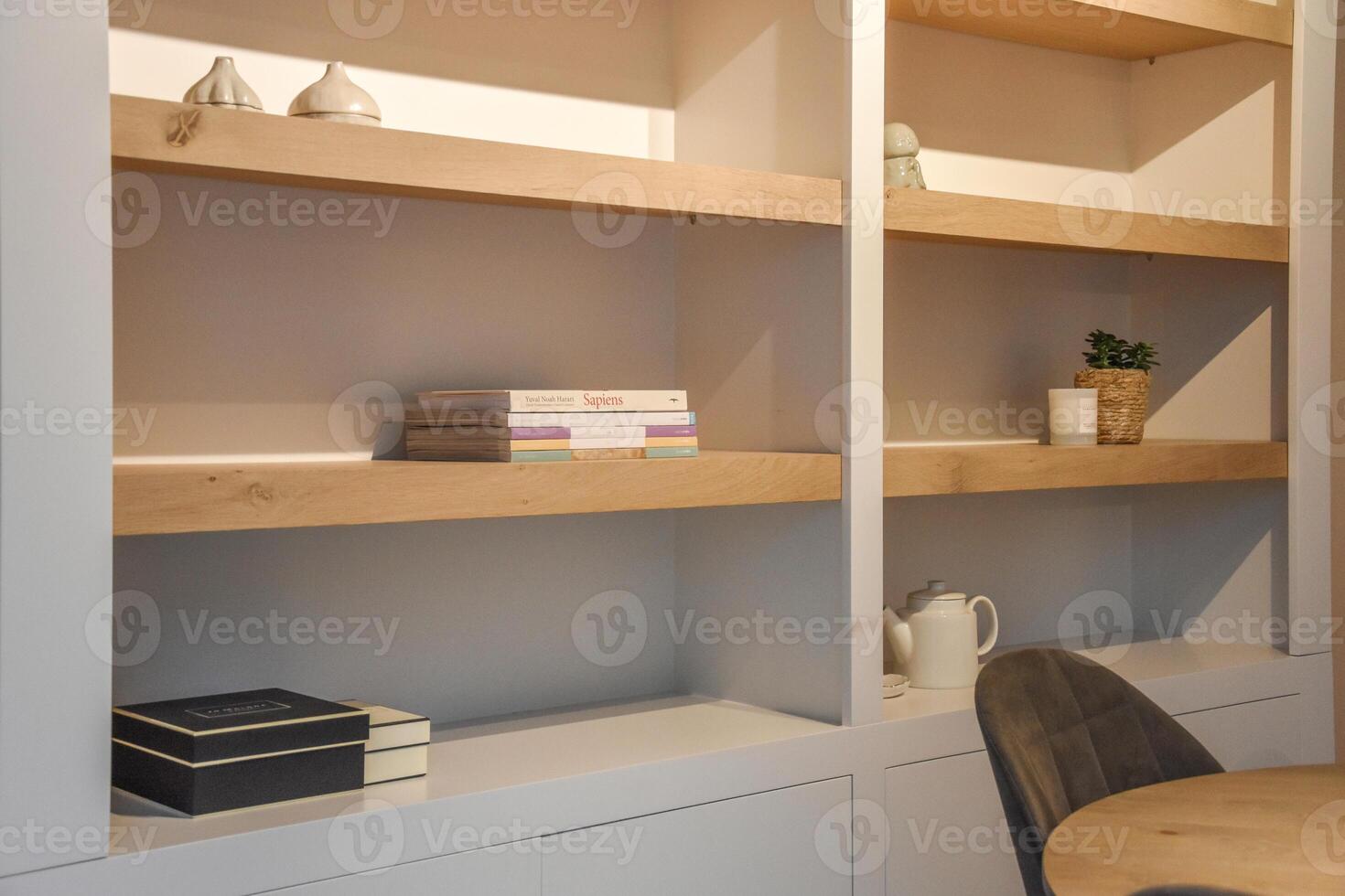 A bookcase with books and a chair in a room photo