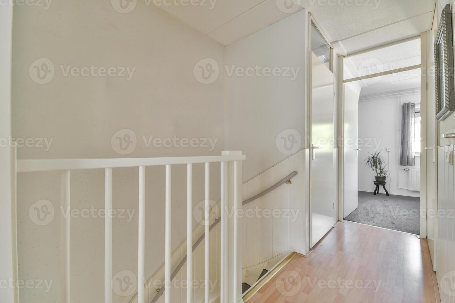 A hallway with a white railing and wooden floors photo