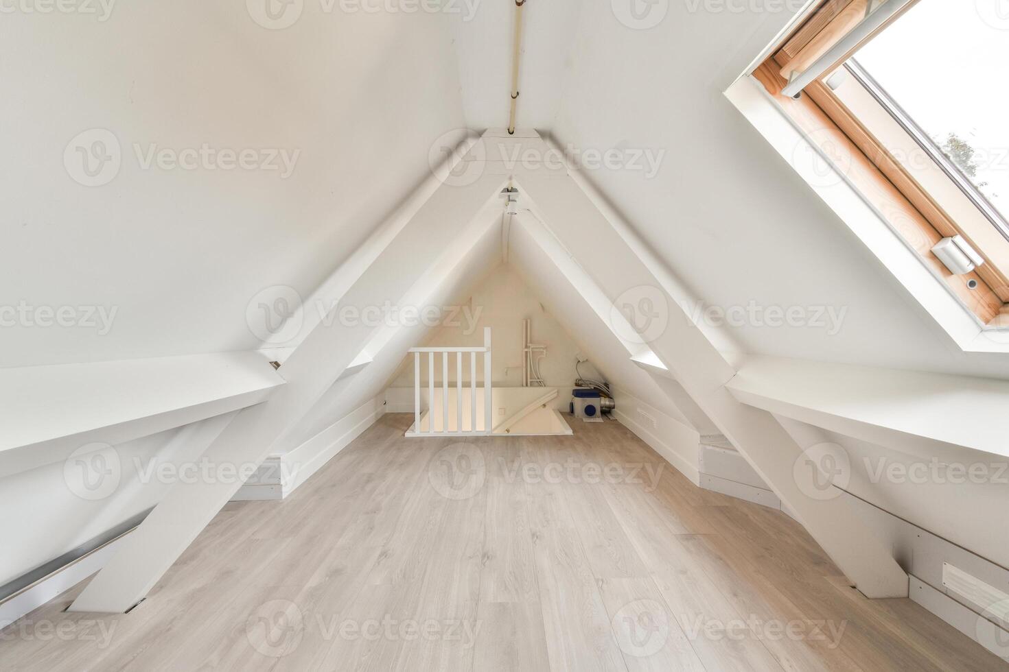 A white attic with a wooden floor and a window photo