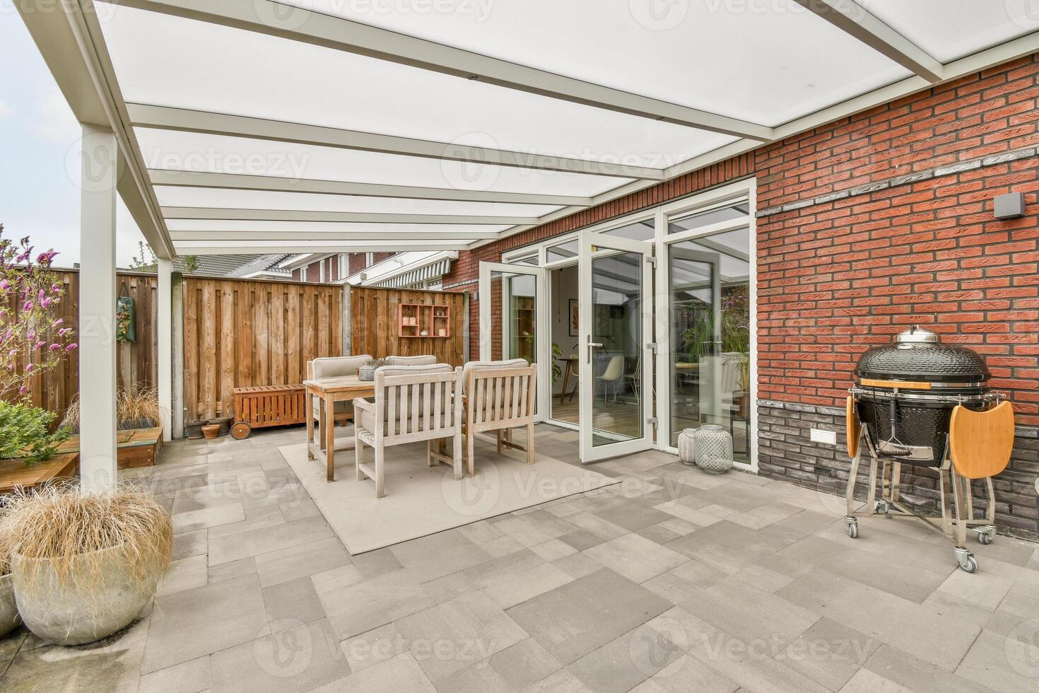 A patio with a grill and table photo