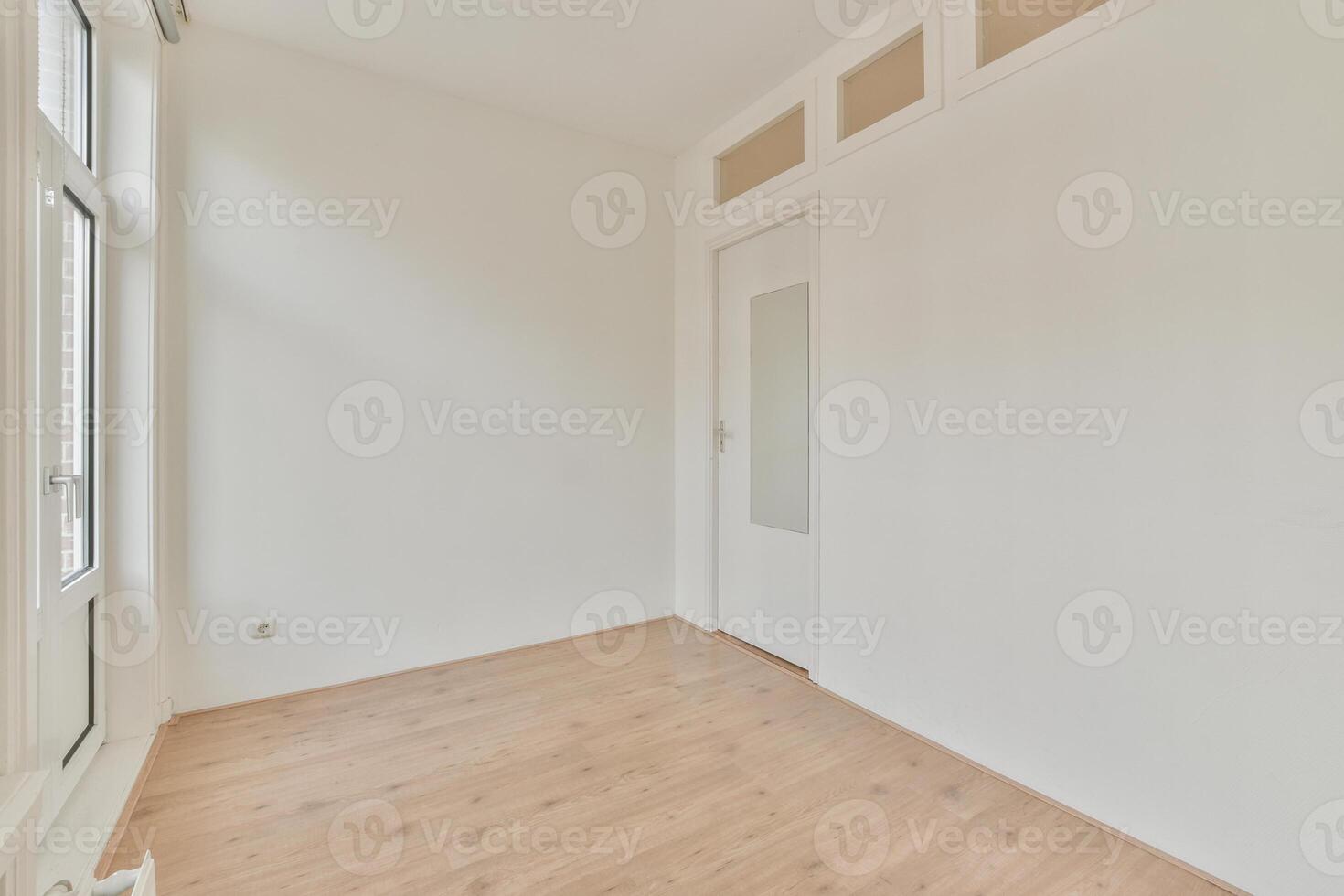 An empty room with a wooden floor and white walls photo