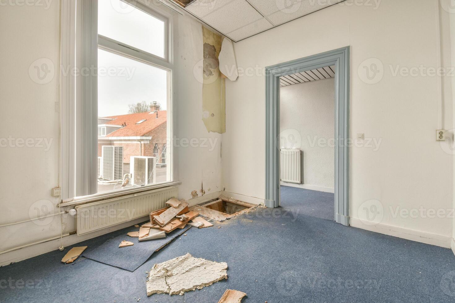 An empty room with a broken window and a door photo