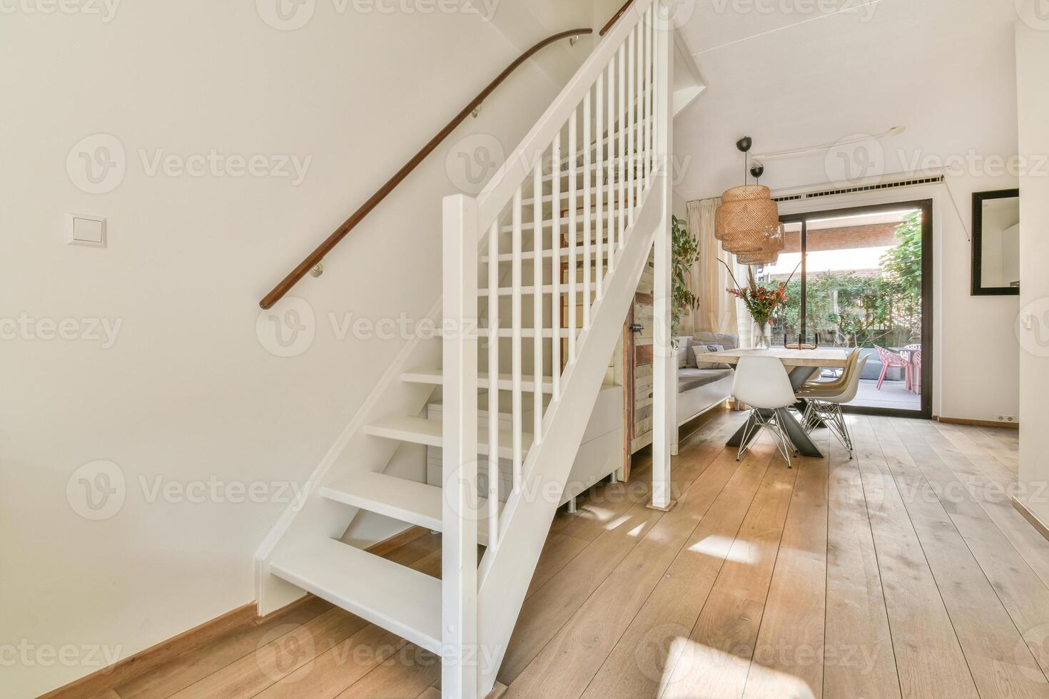 A white stairway leads to a dining room and kitchen photo
