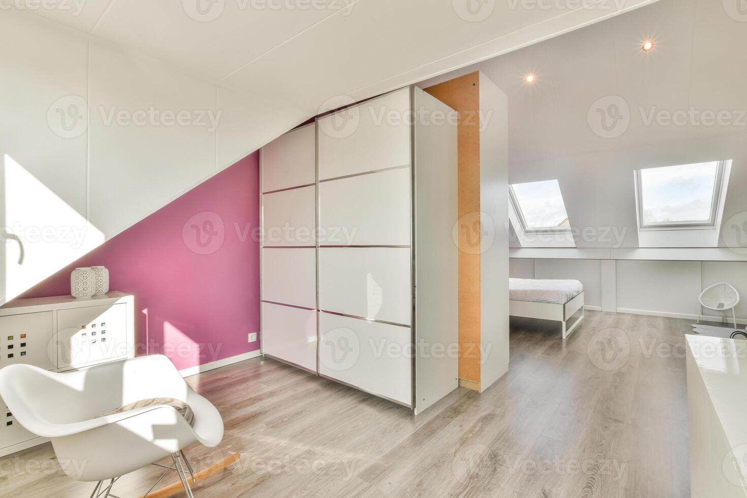 A bedroom with a white bed and pink walls photo