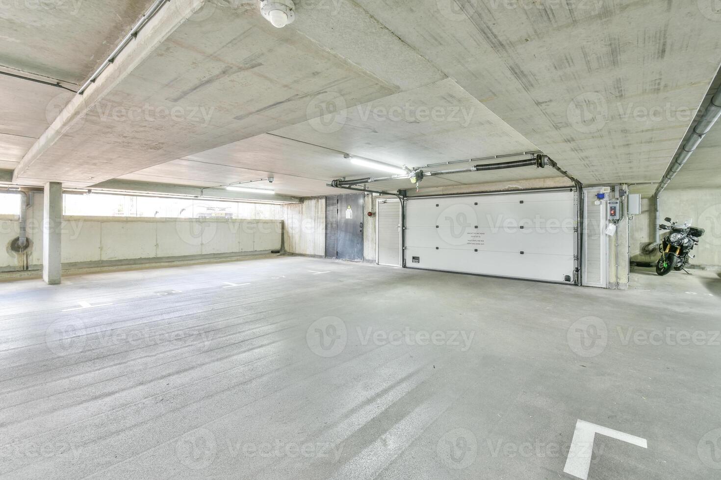 An empty garage with a white wall and a door photo