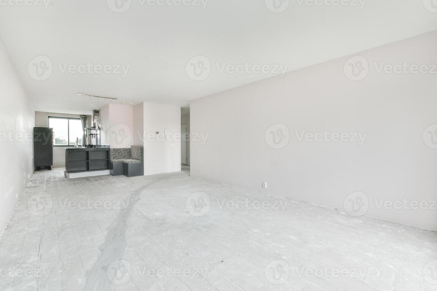 An empty room with white walls and a kitchen photo