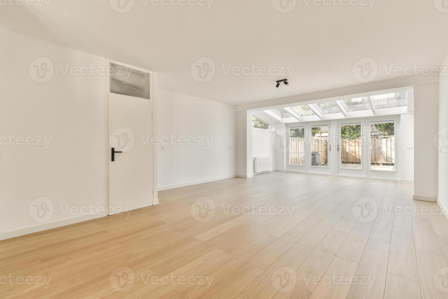 An empty room with wooden floors and white walls photo