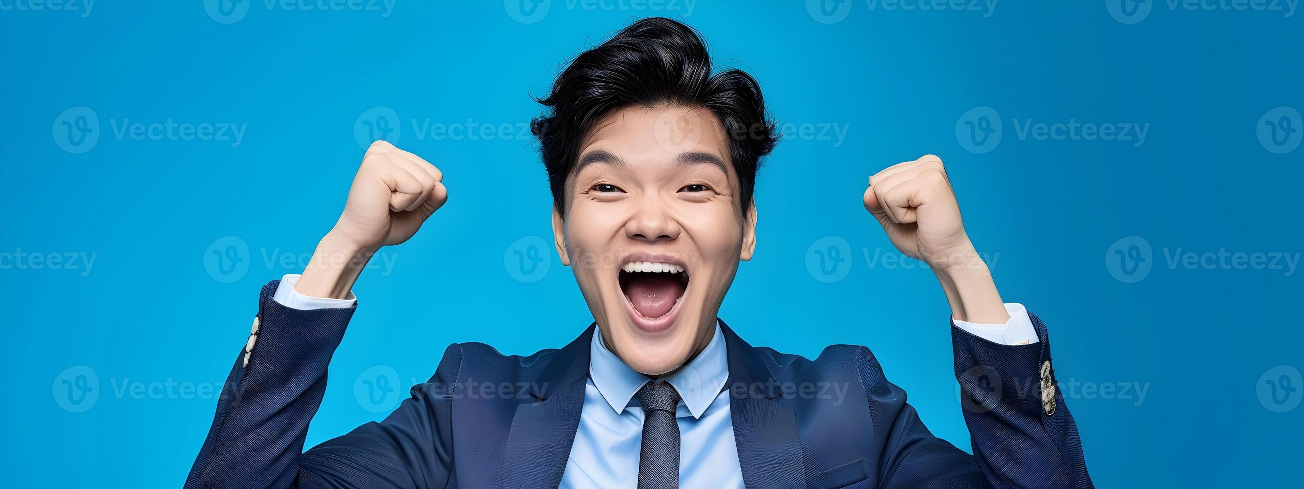 Excited Asian Businessman Celebrates Achievement in Modern Costume on Blue Background photo