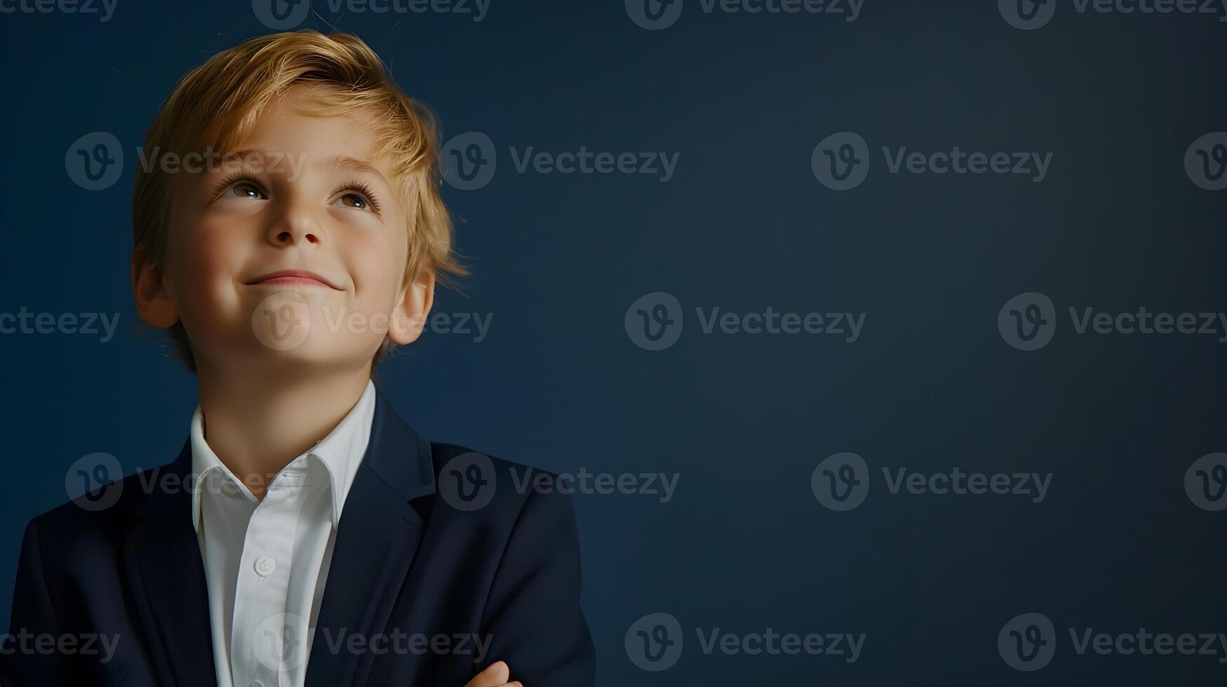 A young boy in a suit and tie looking up photo