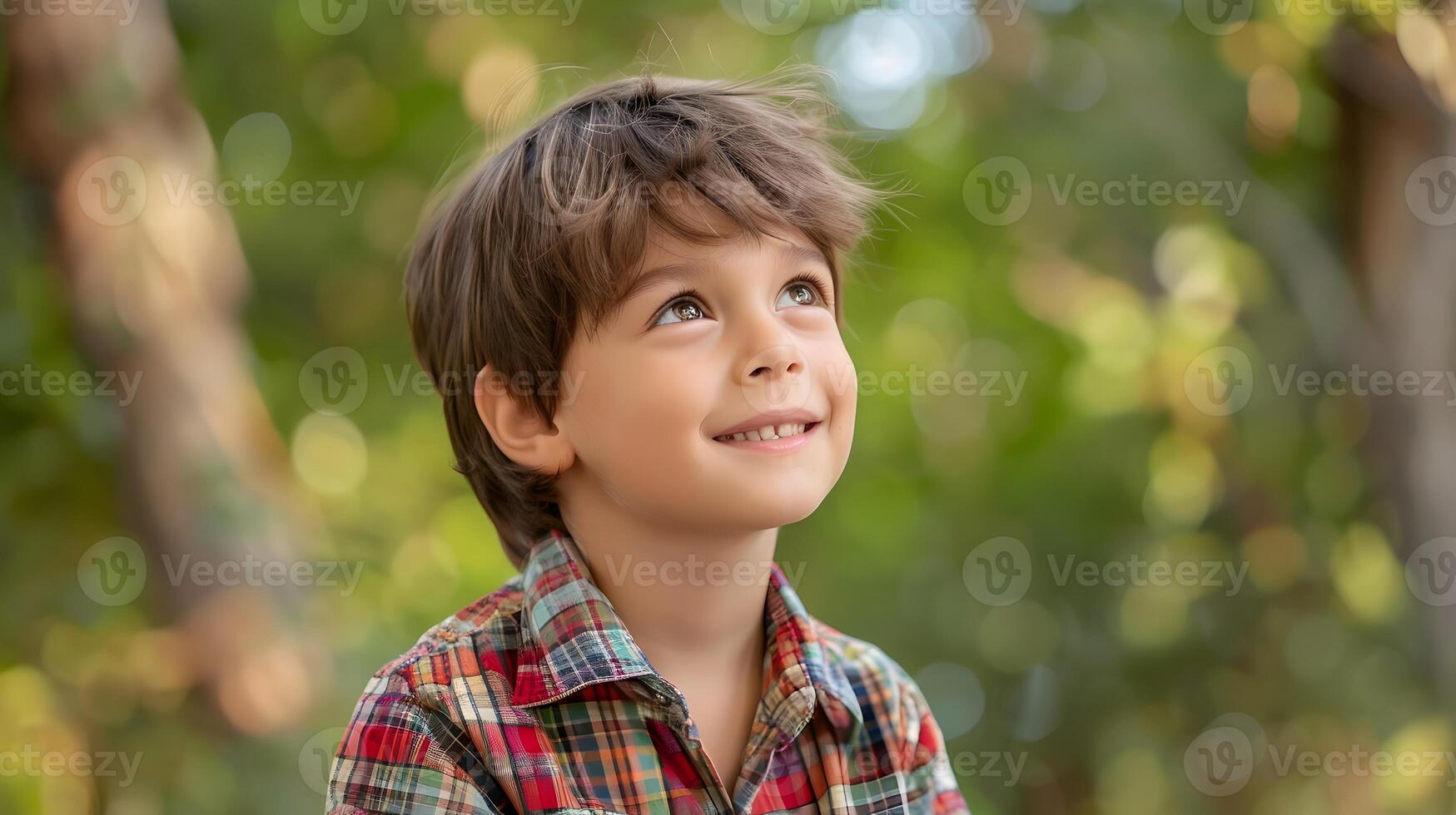 A young boy is smiling while looking up photo