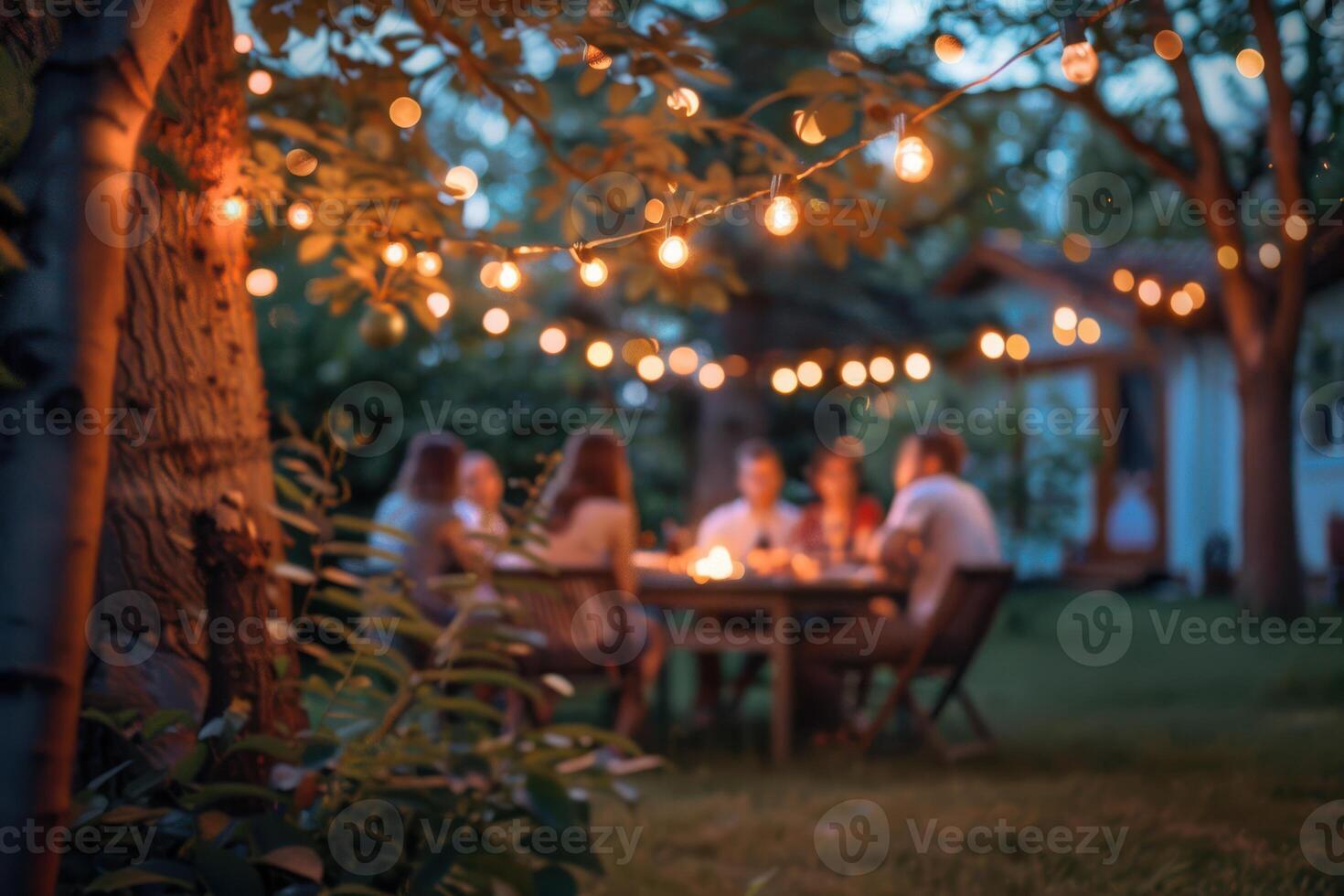 A group of people sitting around a table in the backyard photo