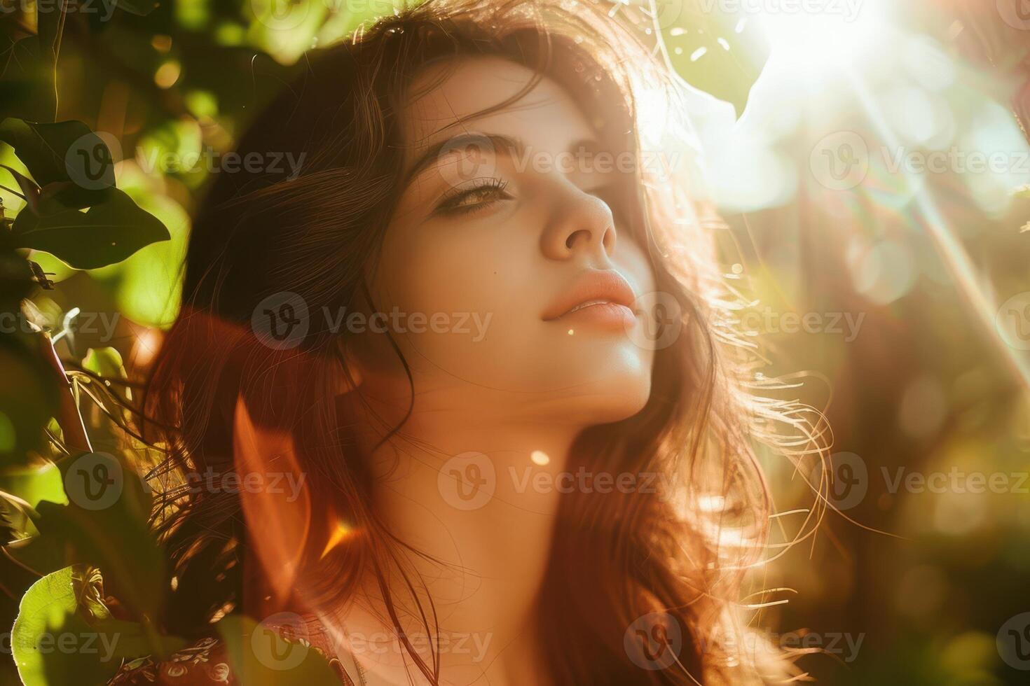 Beautiful woman in the sun with green leaves photo