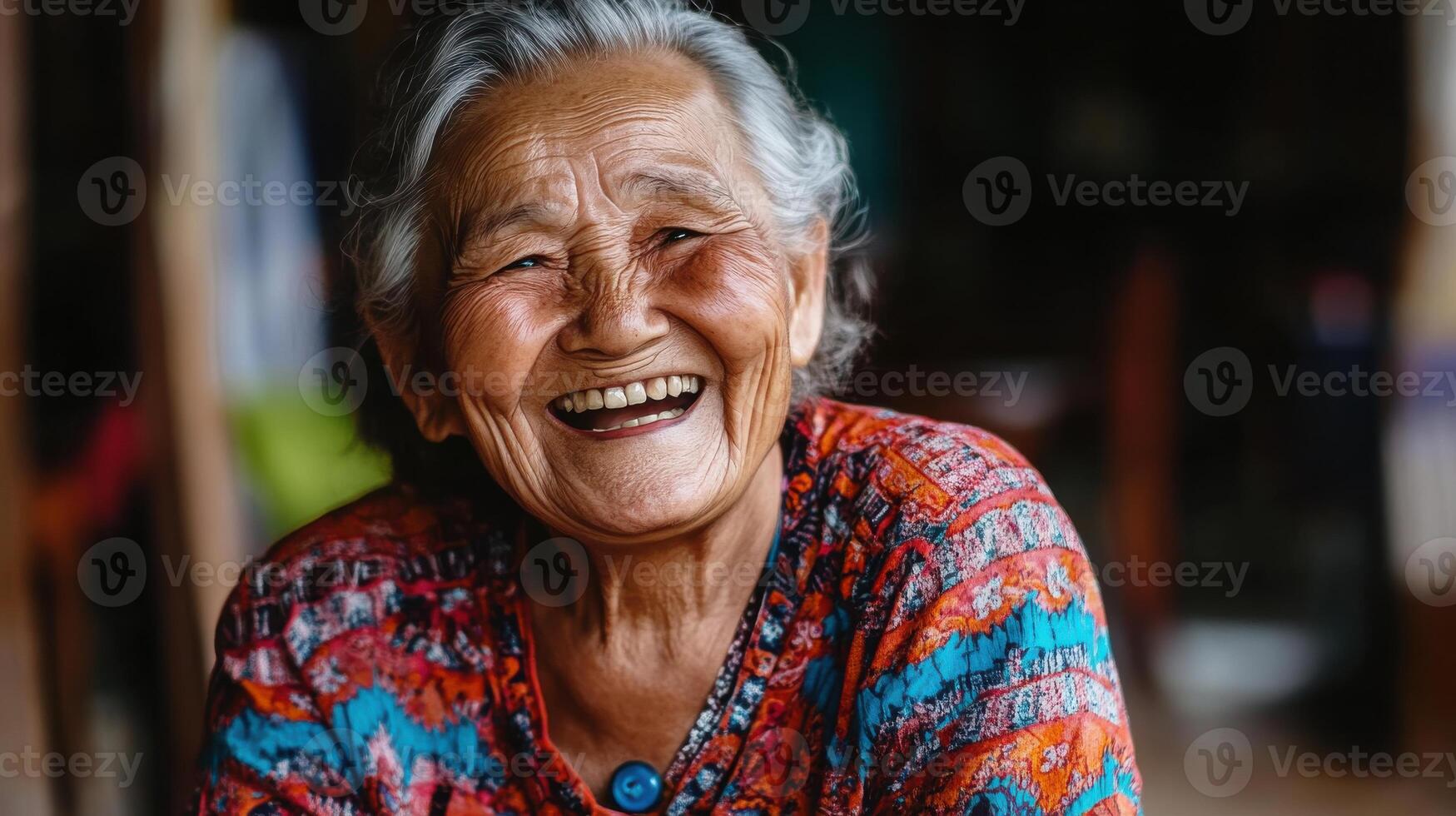 An elderly woman smiles while sitting on a chair photo
