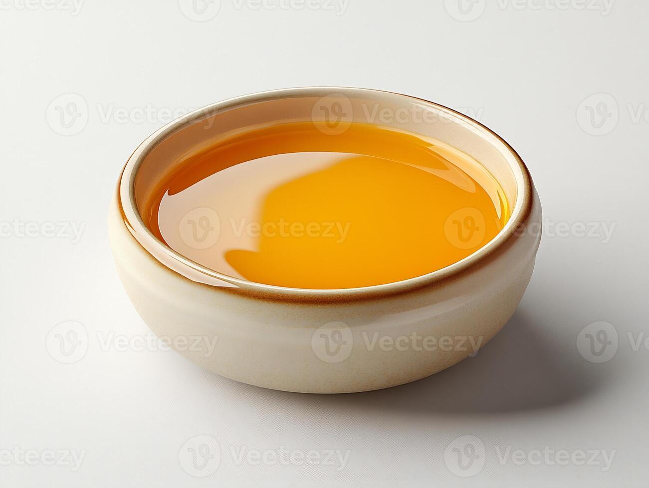 Small dish of tangy lemon butter sauce placed on a white background smooth and glossy photo
