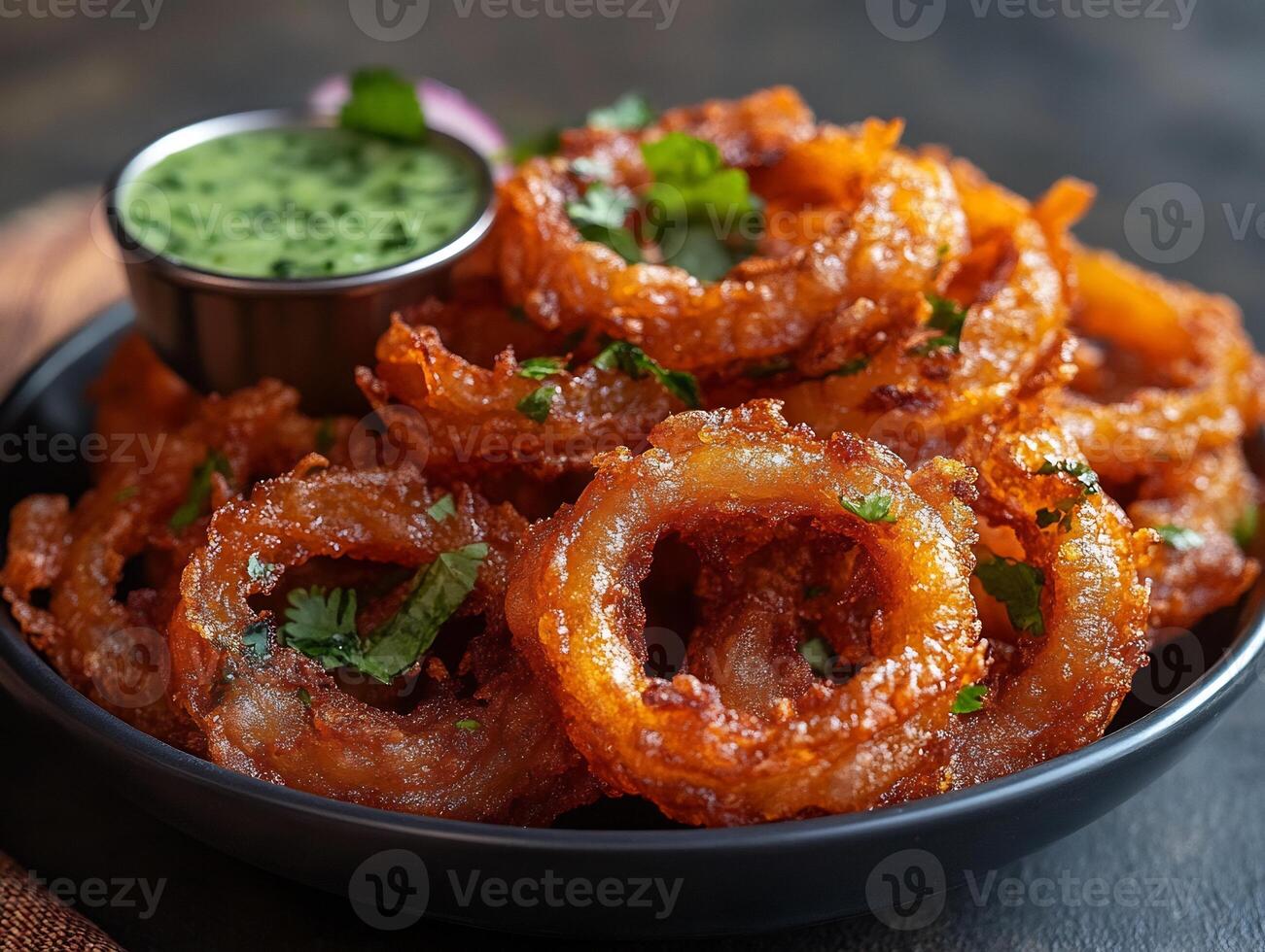 Crispy onion bhajis served a side of mint chutney freshly fried and golden in color photo