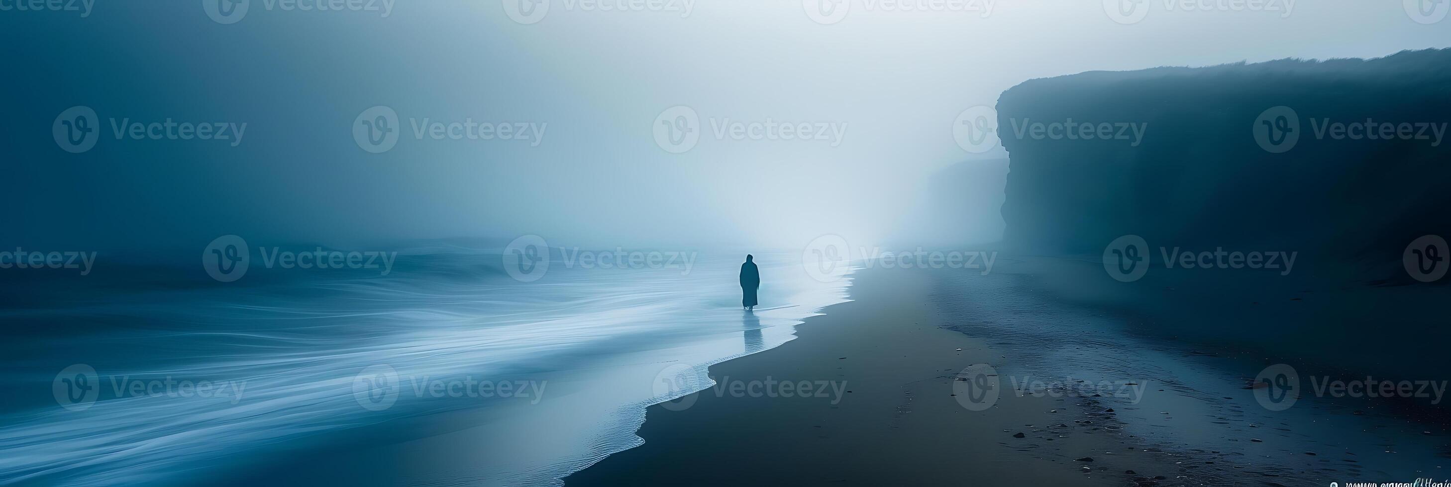 Minimalist long exposure image of a solitary figure walking along a deserted beach with their movement captured in light photo