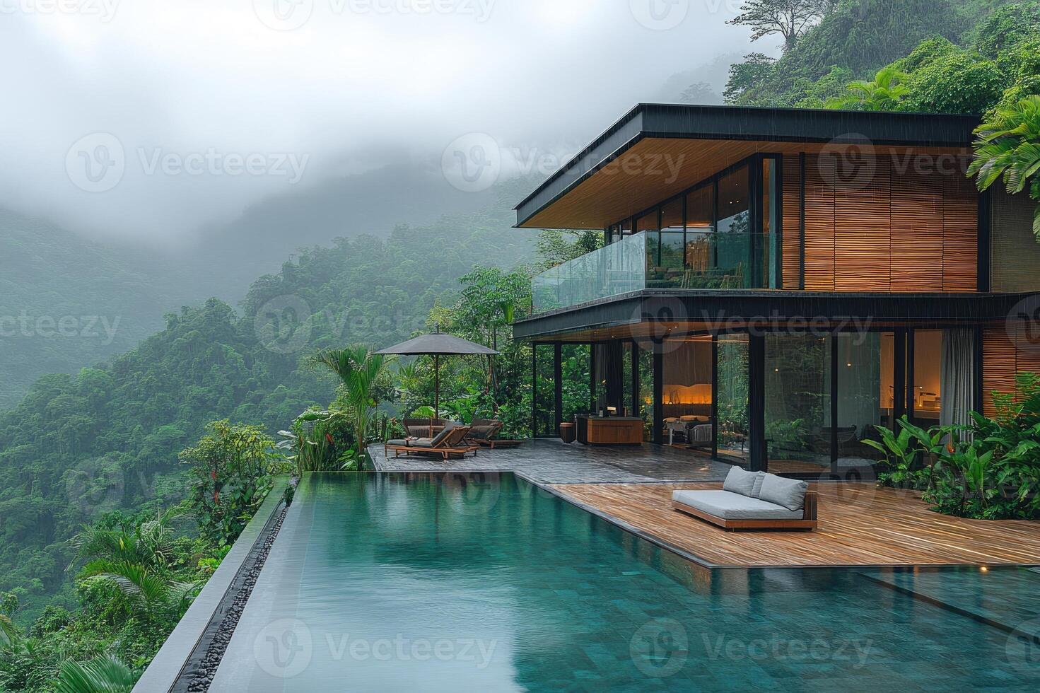 Modern luxury villa overlooking tropical forest with infinity pool during rain shower photo
