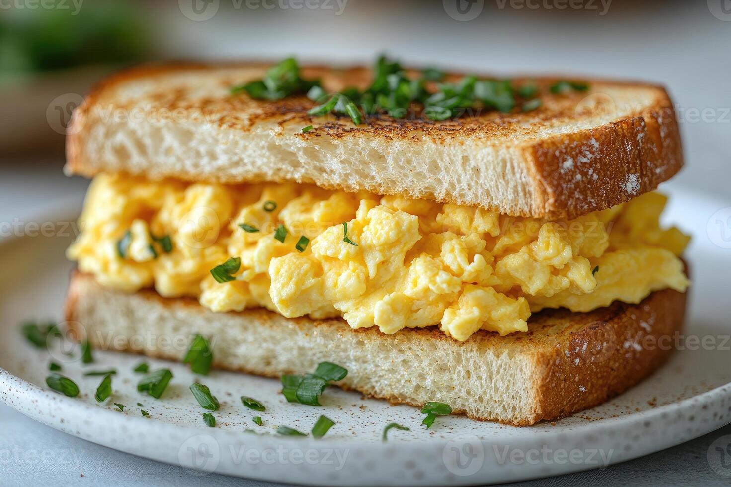 Delicious scrambled eggs sandwich with toasted bread and greens for breakfast photo