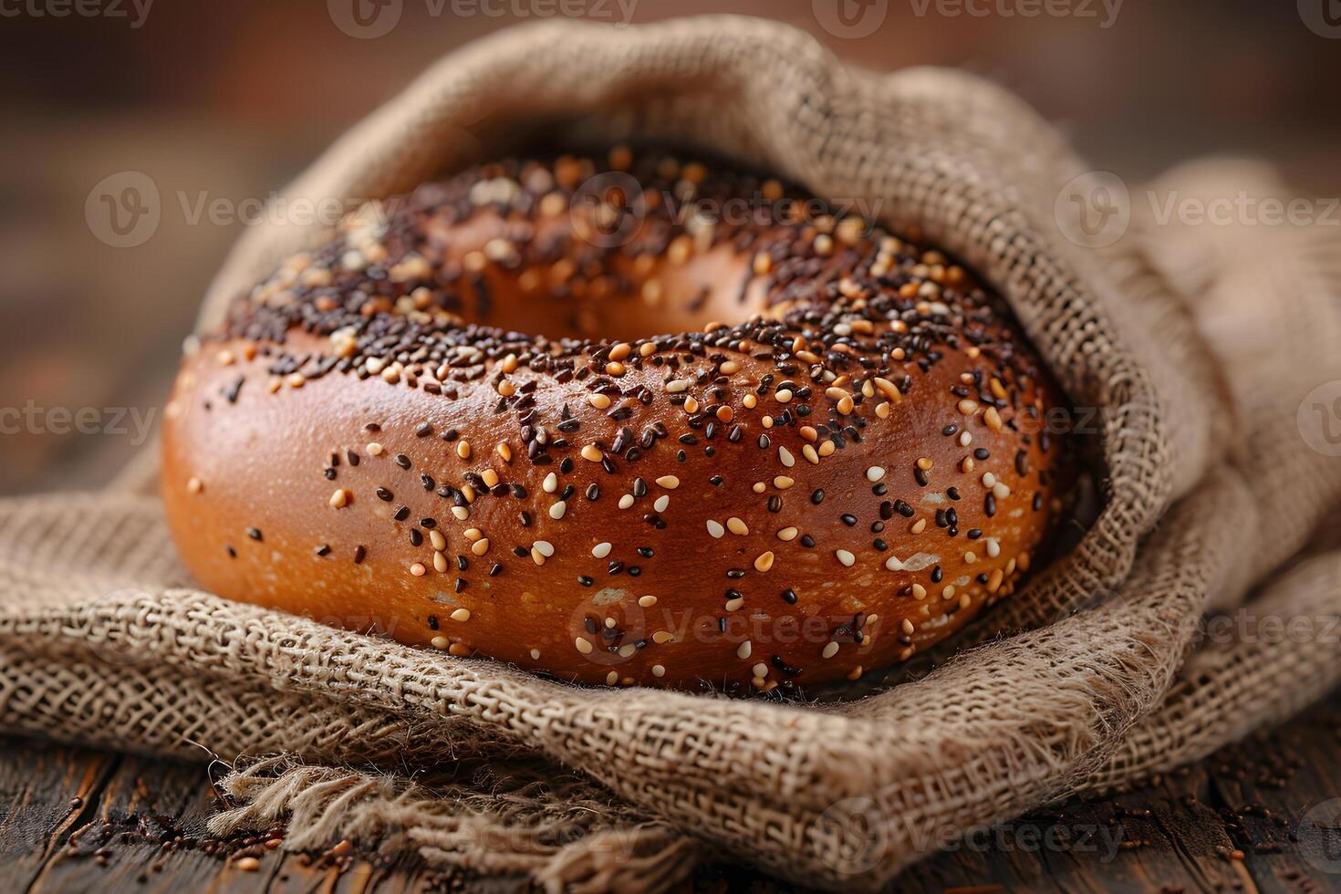Freshly Baked Bagel with Mixed Seeds on Rustic Burlap Perfect for Breakfast and Bakery Promotions photo