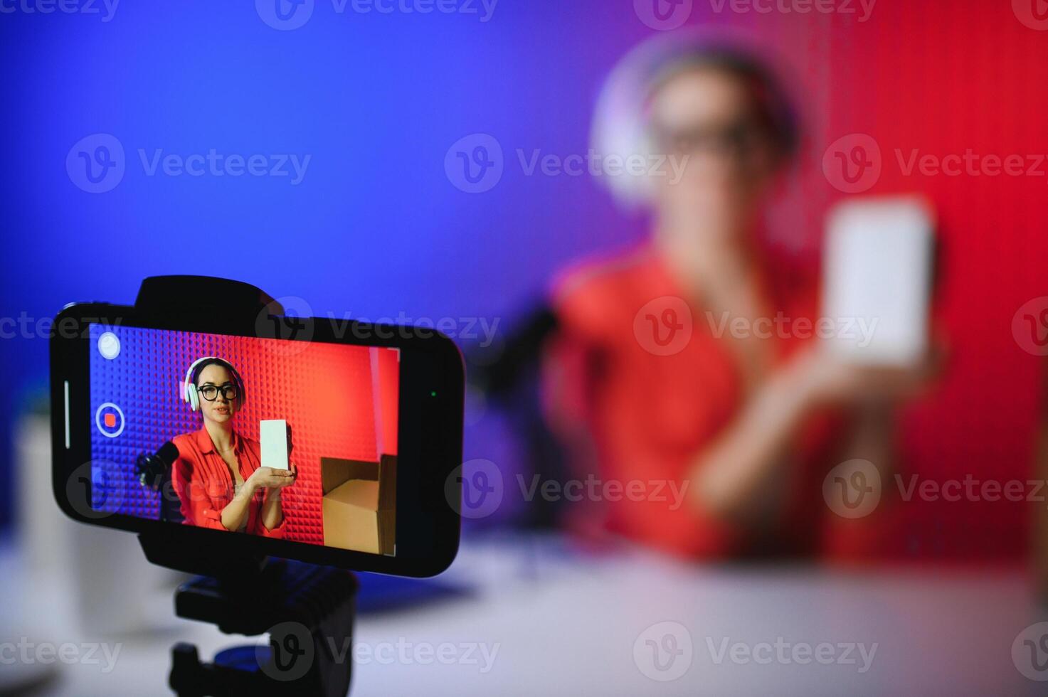 A young blogger girl is recording a and unboxing her new phone photo