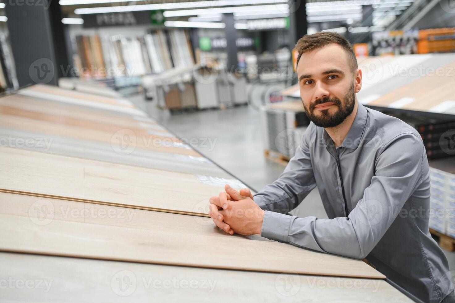 A male salesman-consultant in a hardware store sells laminate photo