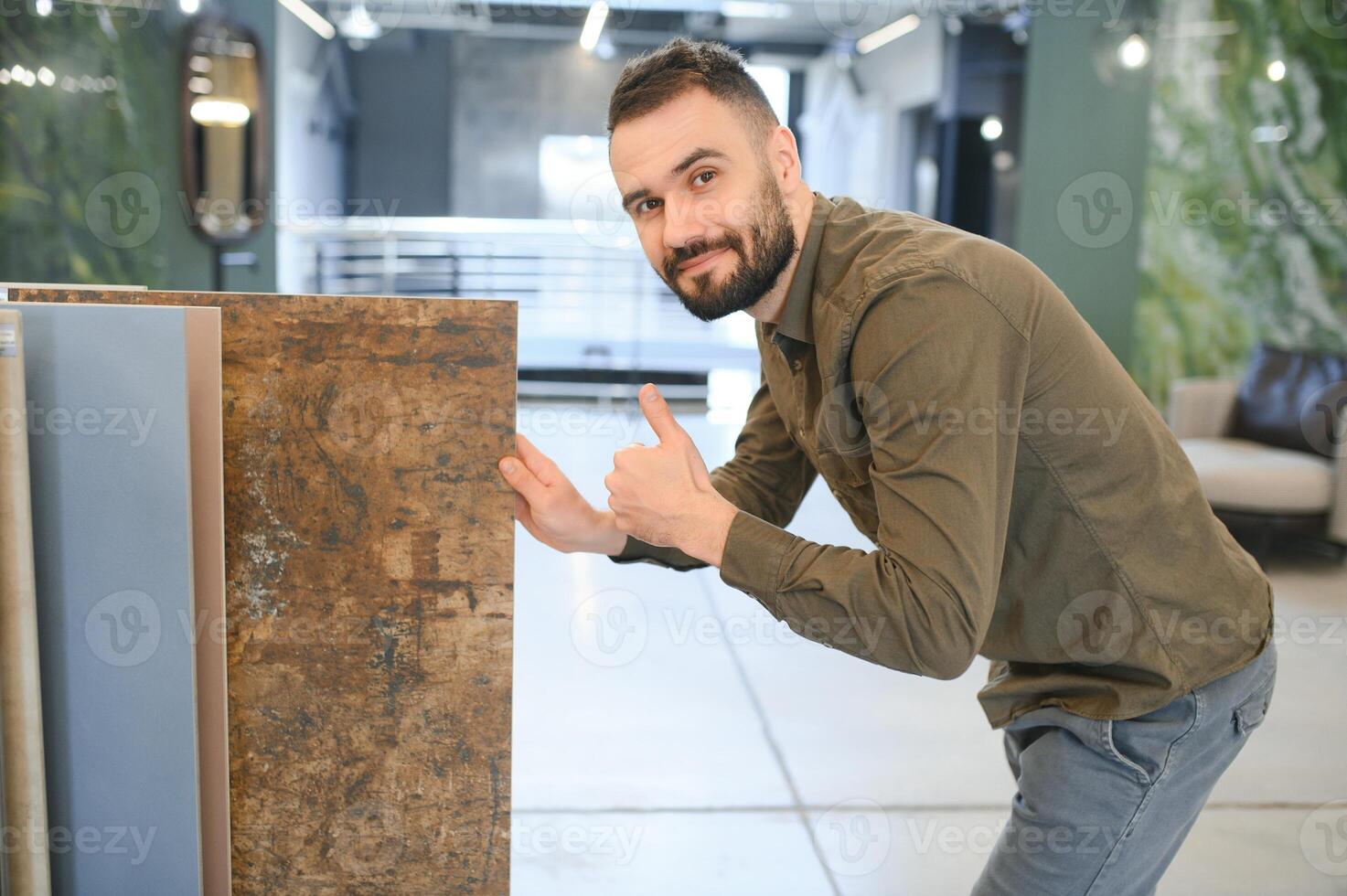 Man choosing tile among different samples in store photo