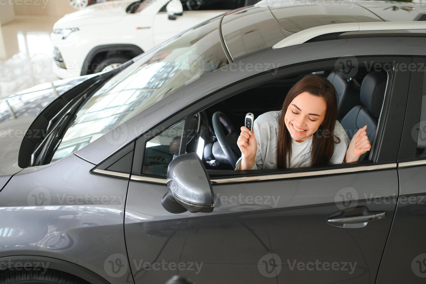 Happy woman with car key sitting in modern auto. Banner design photo