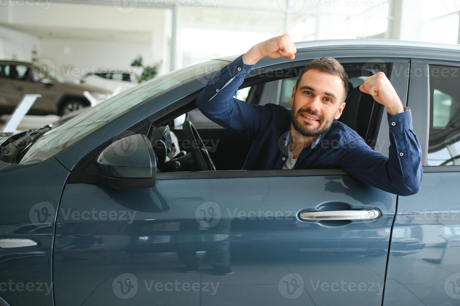 Young man is choosing a new vehicle in car dealership photo