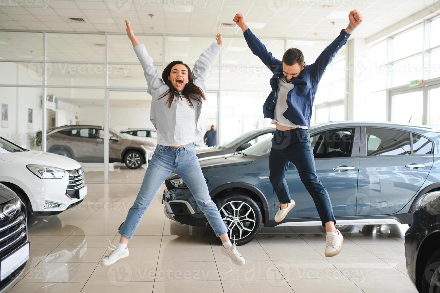 Happy young couple chooses and buying a new car for the family. Visitting the dealership photo