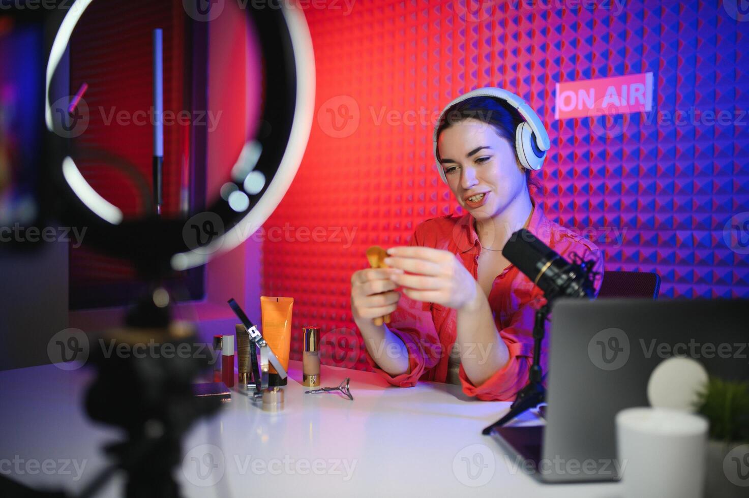 Beauty blogger woman filming daily make-up routine tutorial near camera on tripod photo