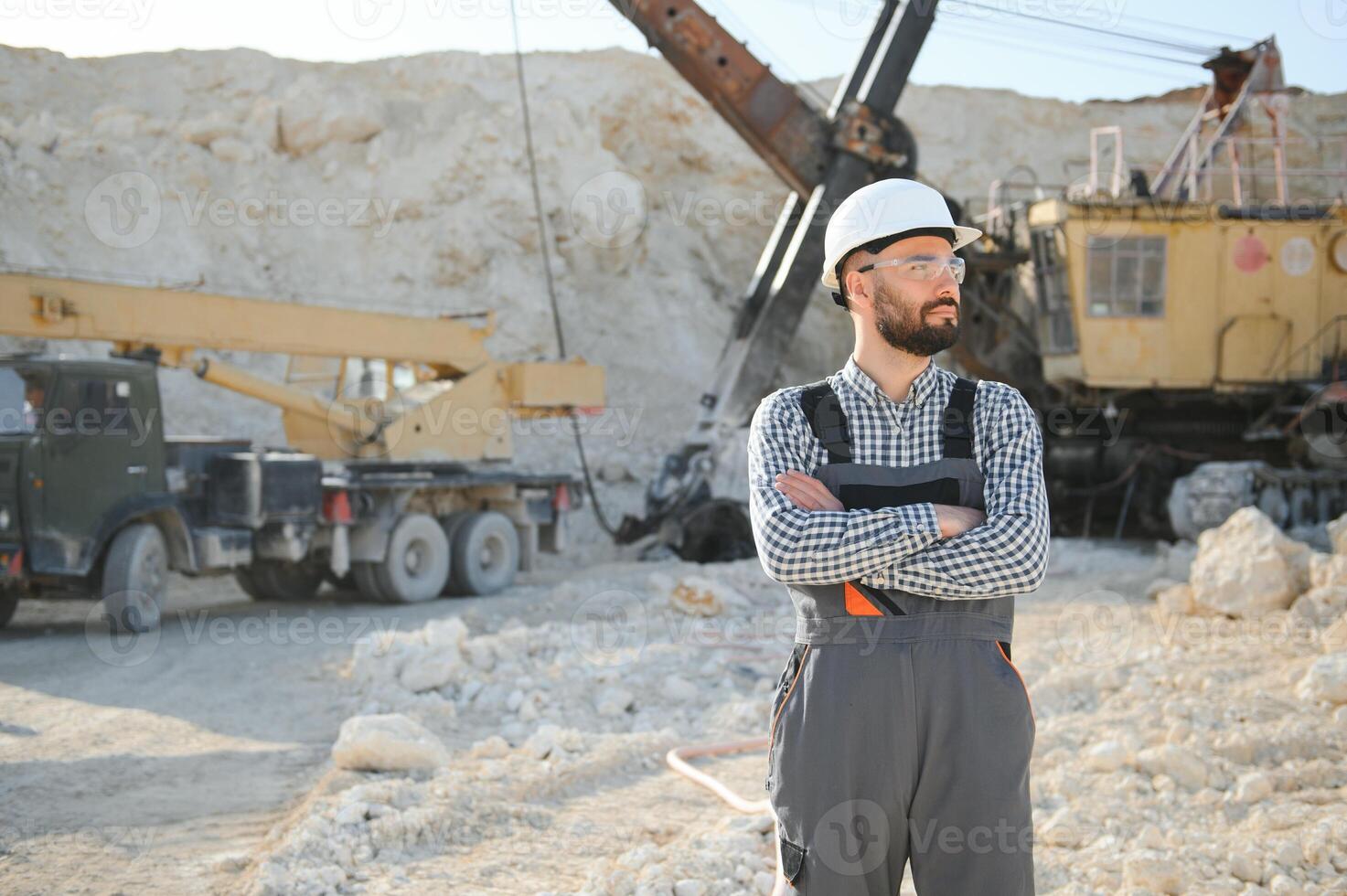 Male worker with bulldozer in sand quarry photo