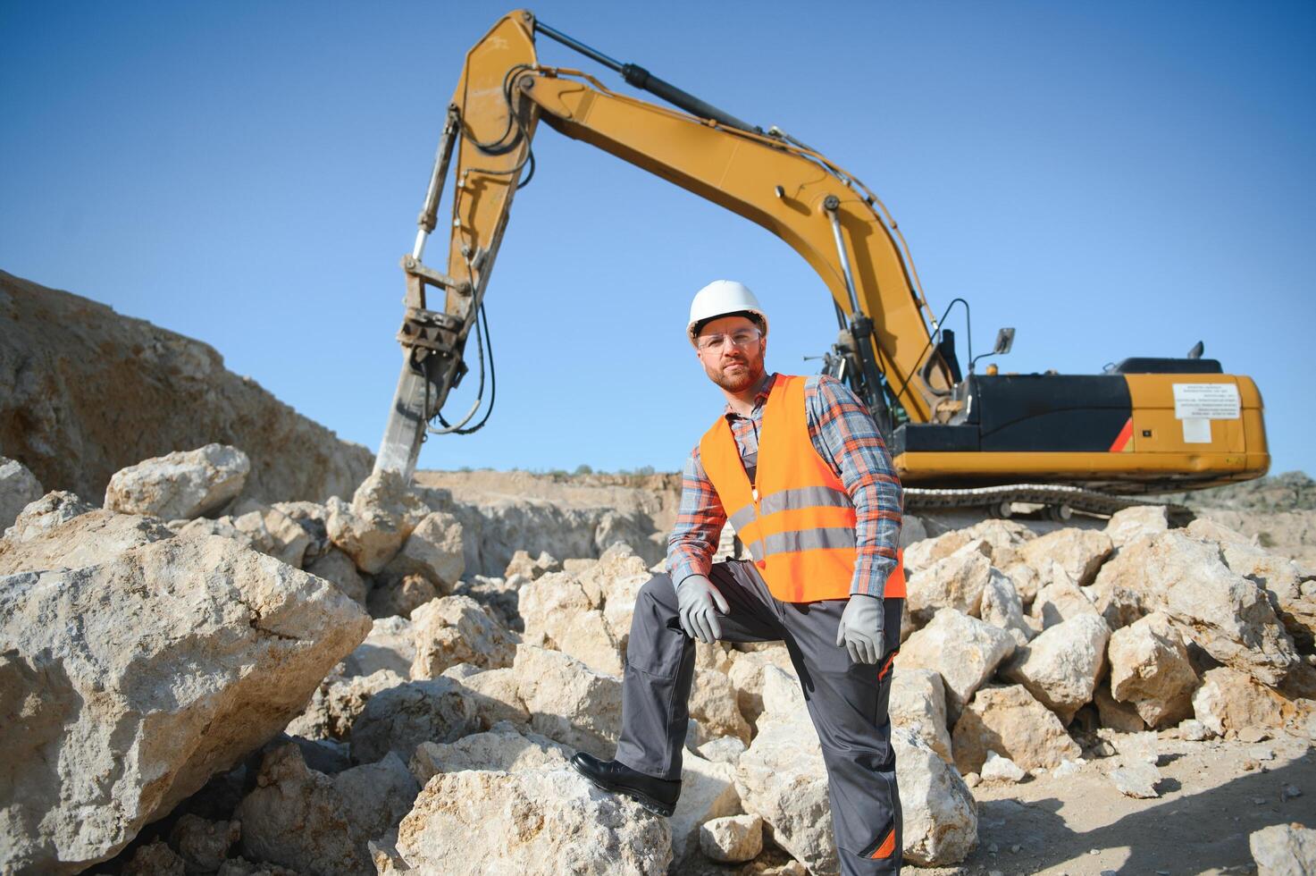 Extraction of stone. Male worker next to stone quarry. Engineer at construction site photo