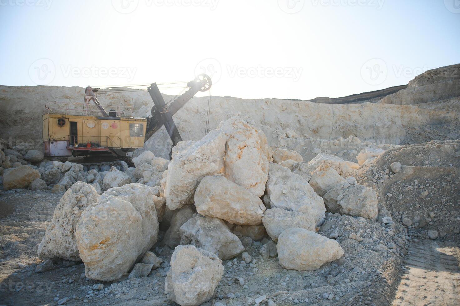 Hydraulic breaker hammer in a quarry for limestone mining with an excavator photo