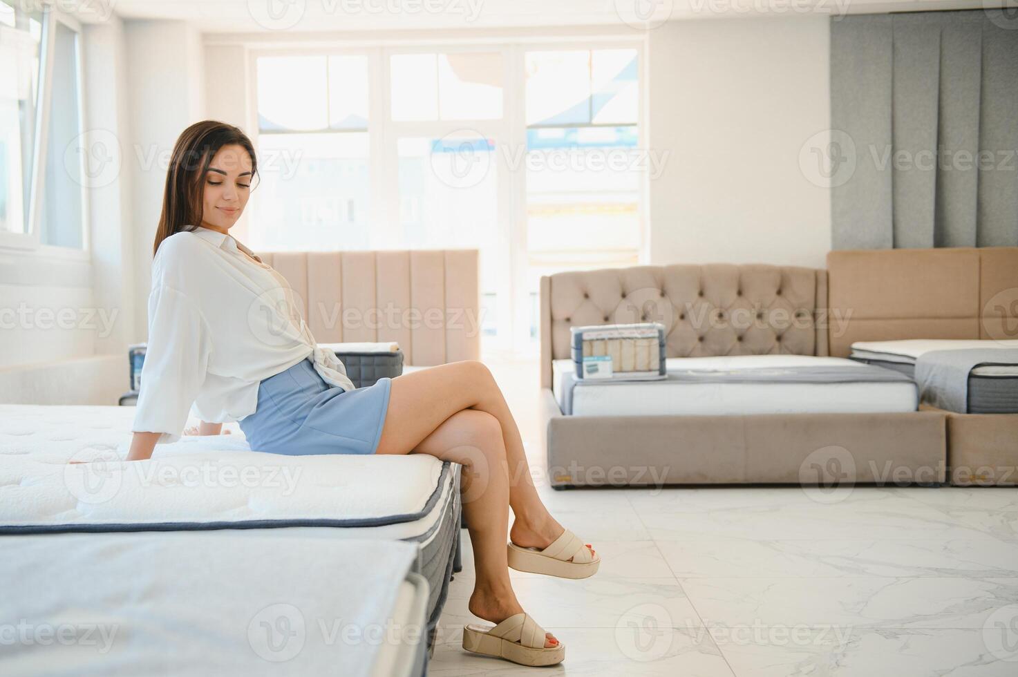 Lovely young woman choosing orthopedic mattress to buy photo