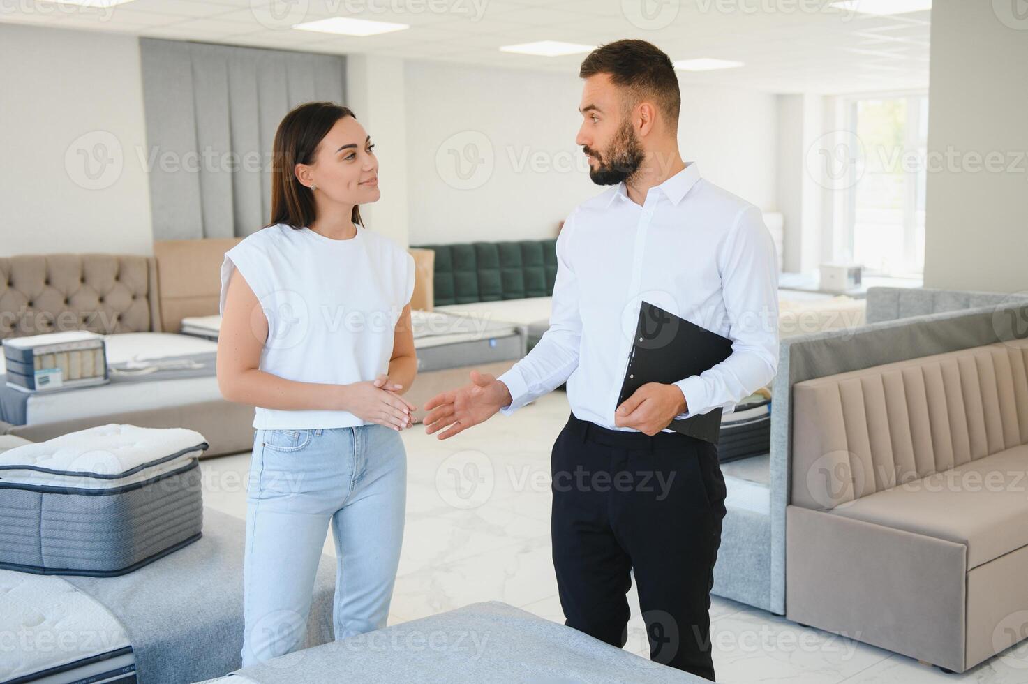 A young salesman consults a female customer in a furniture store photo