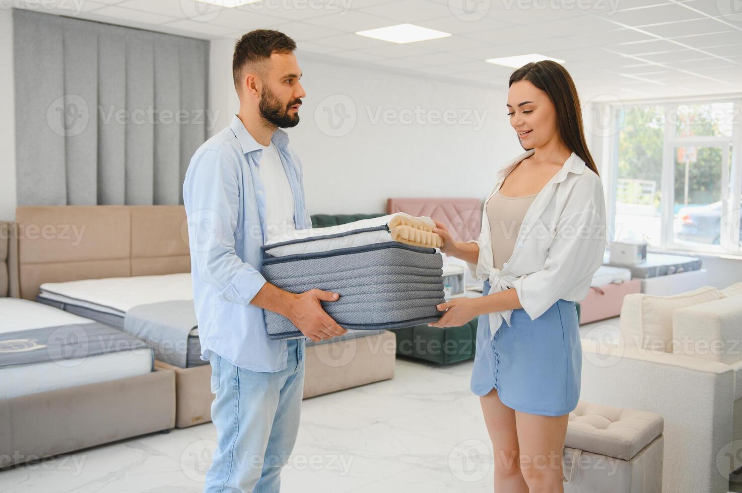 A beautiful young couple chooses a new mattress in a store photo