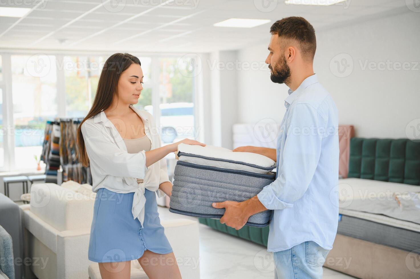 A young couple is choosing bedding at a bed, mattress and pillow store. Everything for a comfortable sleep photo
