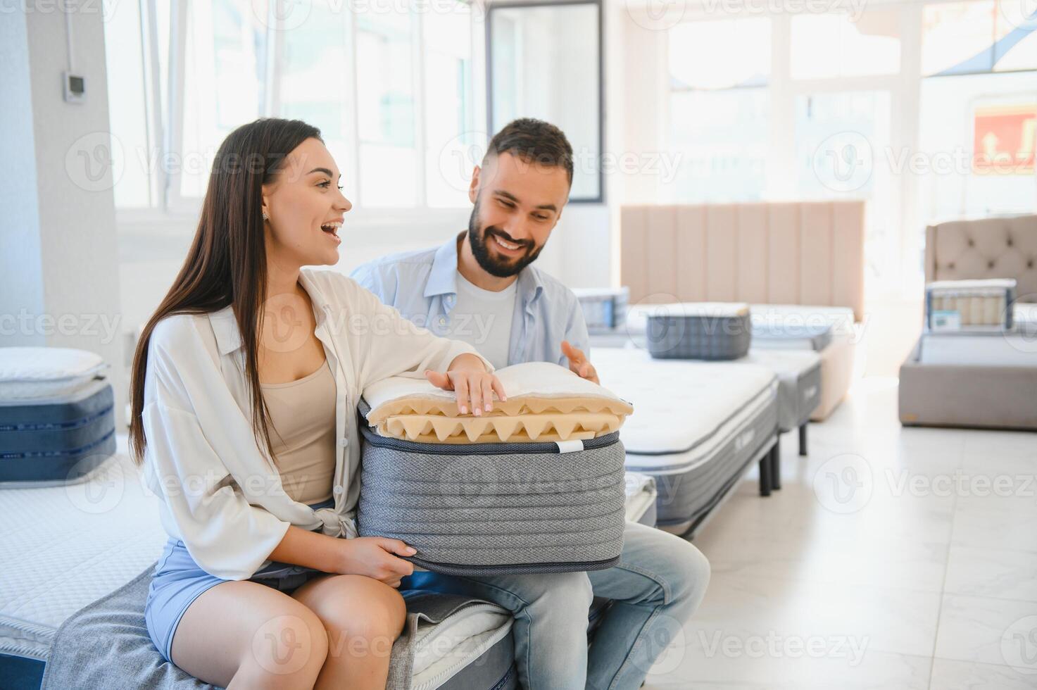 A beautiful young couple chooses a new mattress in a store photo
