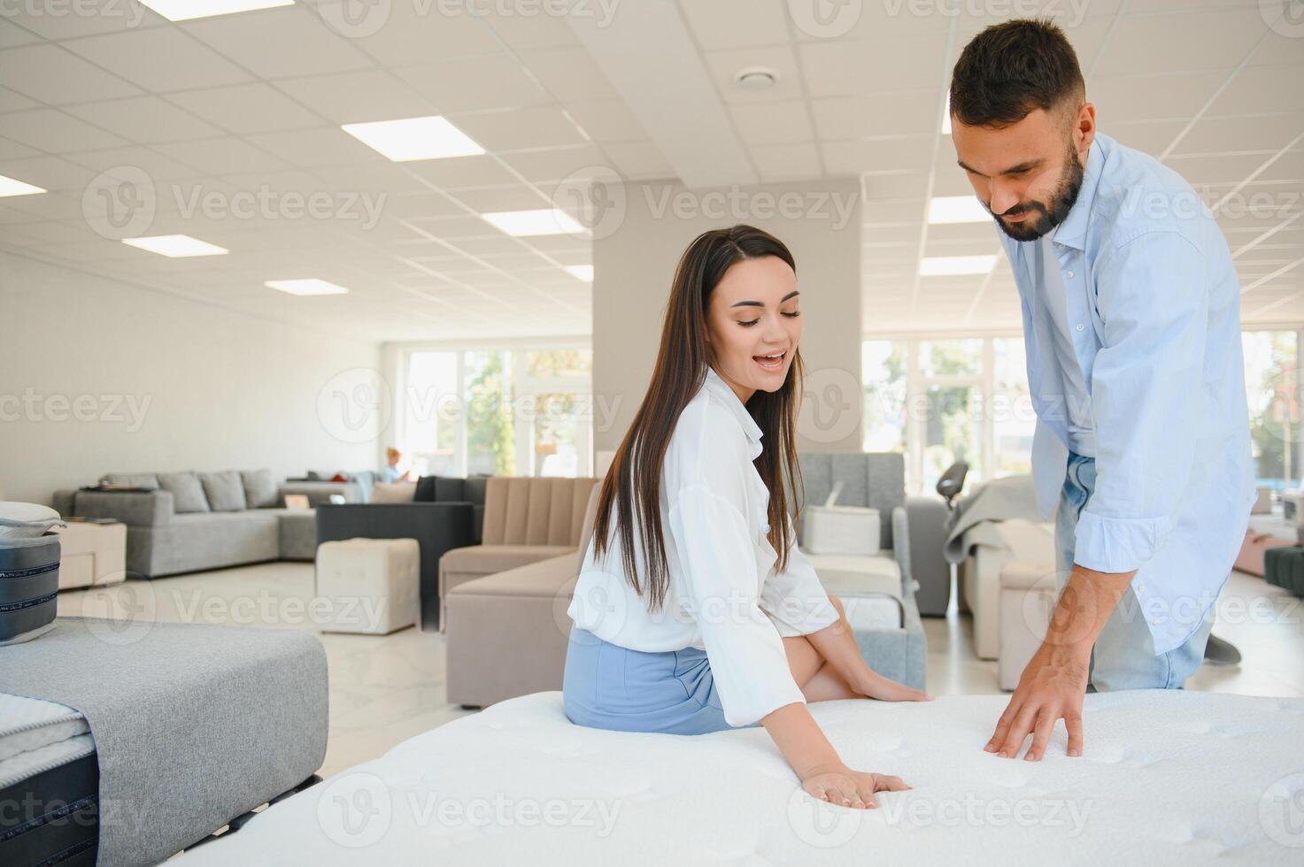 A young couple is choosing bedding at a bed, mattress and pillow store. Everything for a comfortable sleep photo