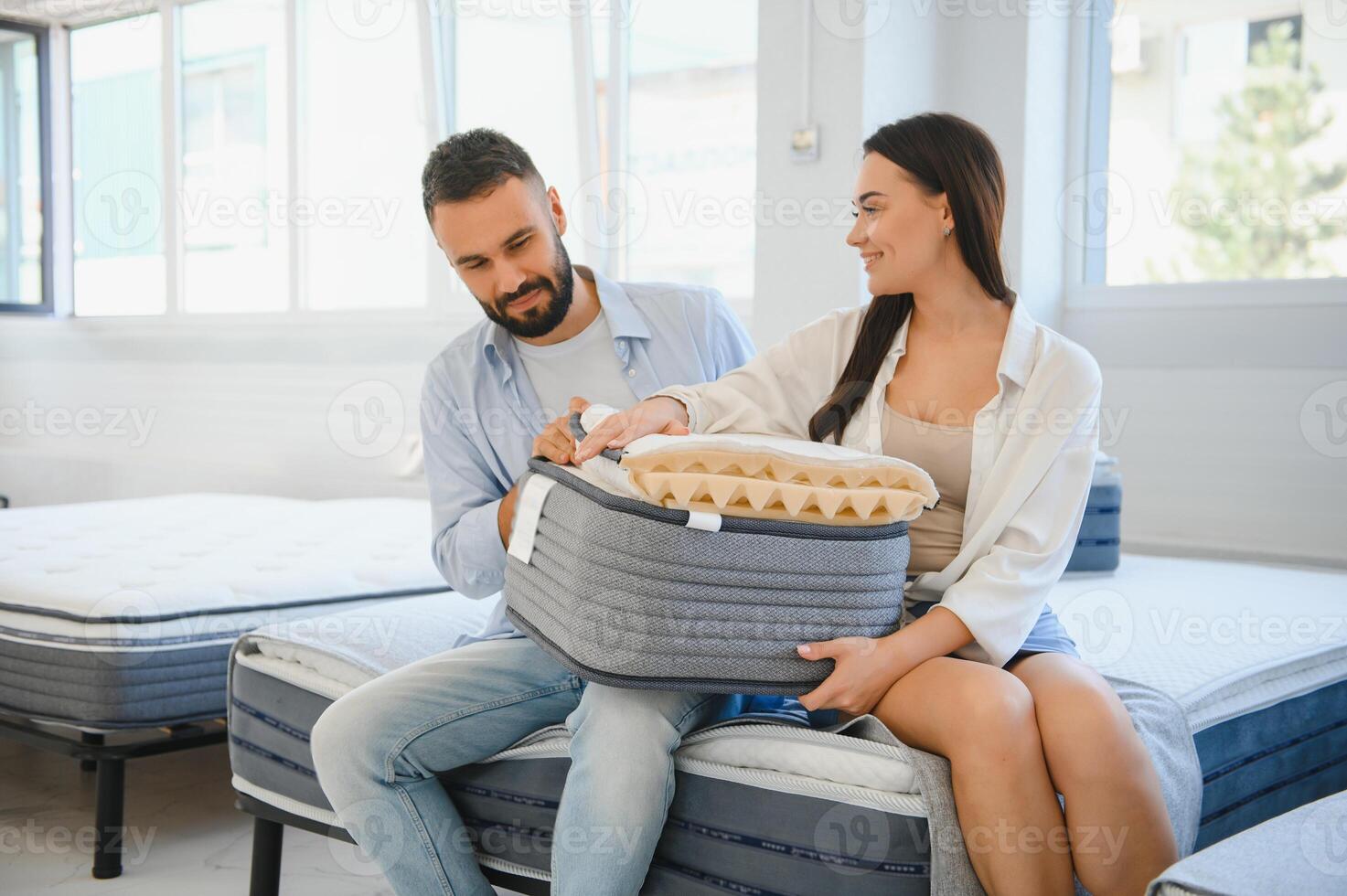 A beautiful young couple chooses a new mattress in a store photo
