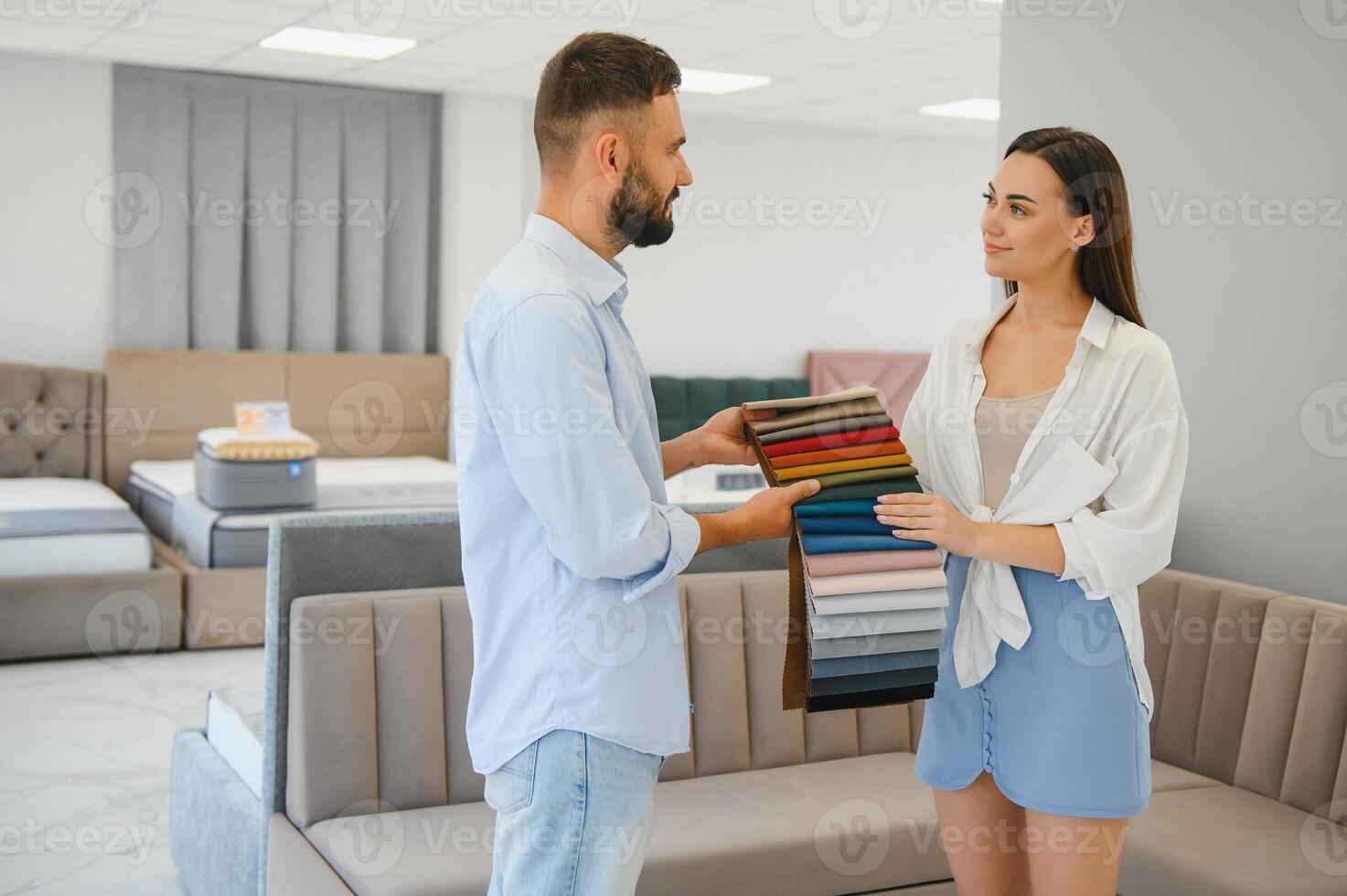 Focus on samples of colored fabrics for upholstered furniture. Overhead view of couple choosing color and fabric texture for upholstery sofa in the home. Interior design concept. photo