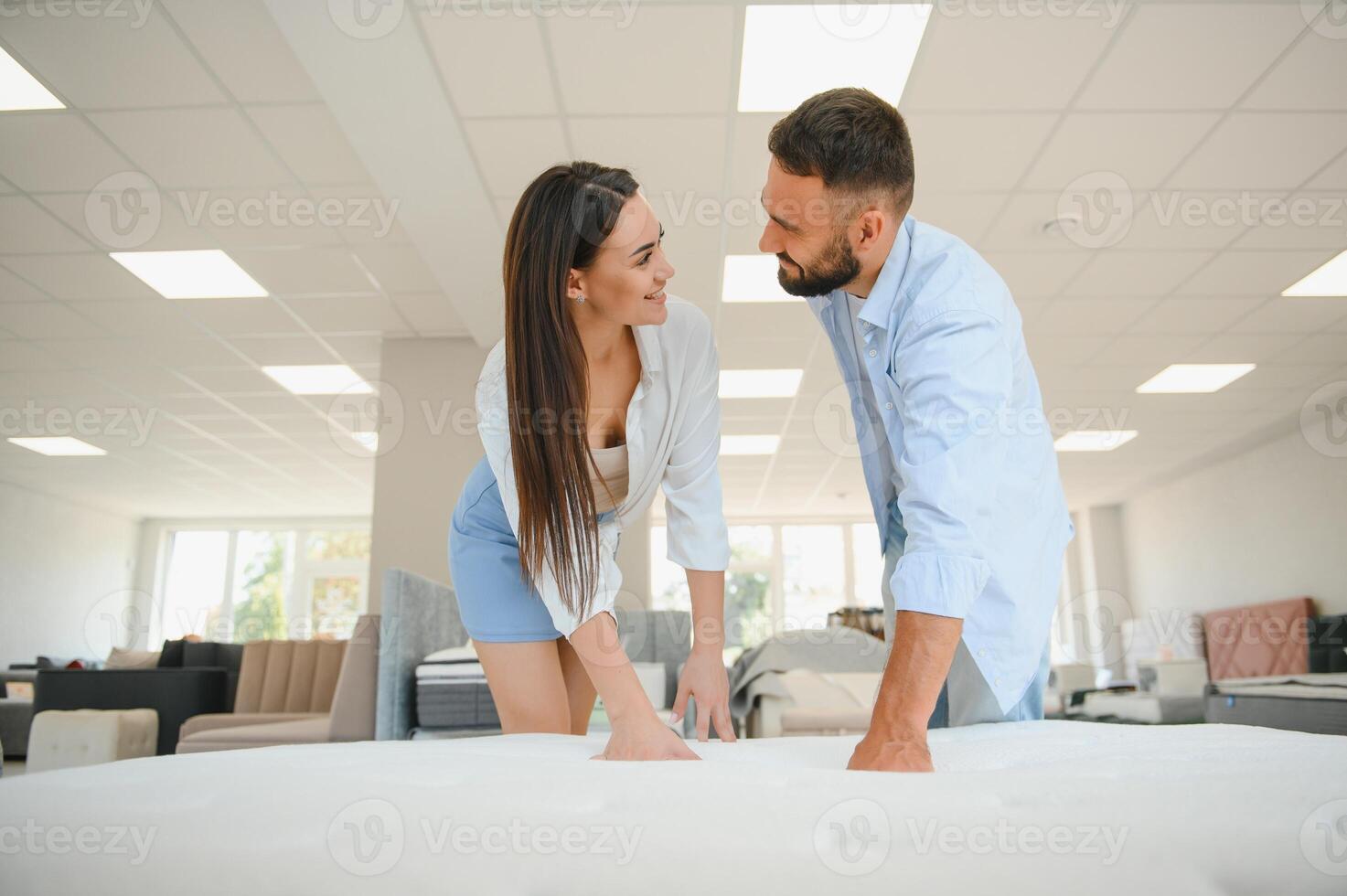 A young couple is choosing bedding at a bed, mattress and pillow store. Everything for a comfortable sleep photo