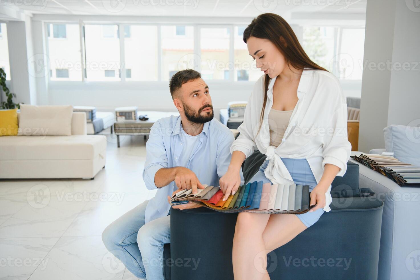 Focus on samples of colored fabrics for upholstered furniture. Overhead view of couple choosing color and fabric texture for upholstery sofa in the home. Interior design concept. photo