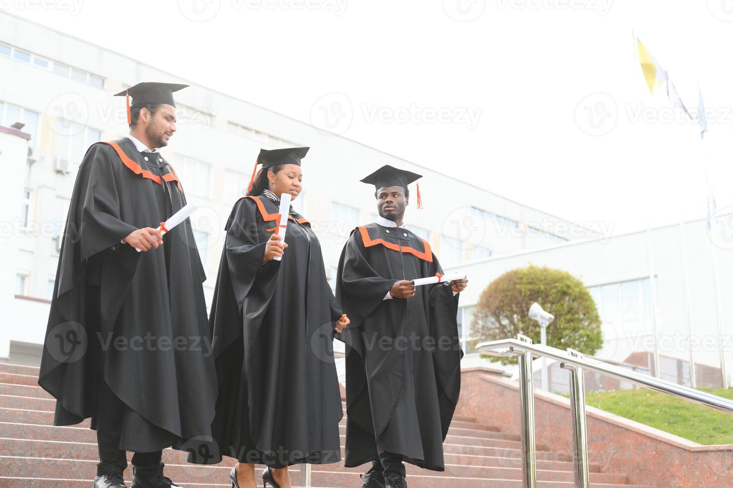 Diverse international students with diplomas at university campus photo